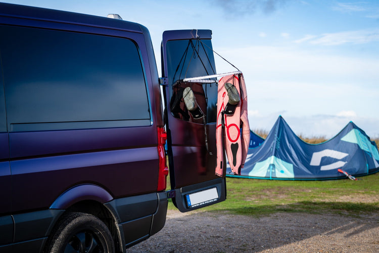 Neoprenanzug und Surfschuhe trocknen an Dryangl Hanger am Van – ideal für Kitesurfer:innen und Camping am Strand